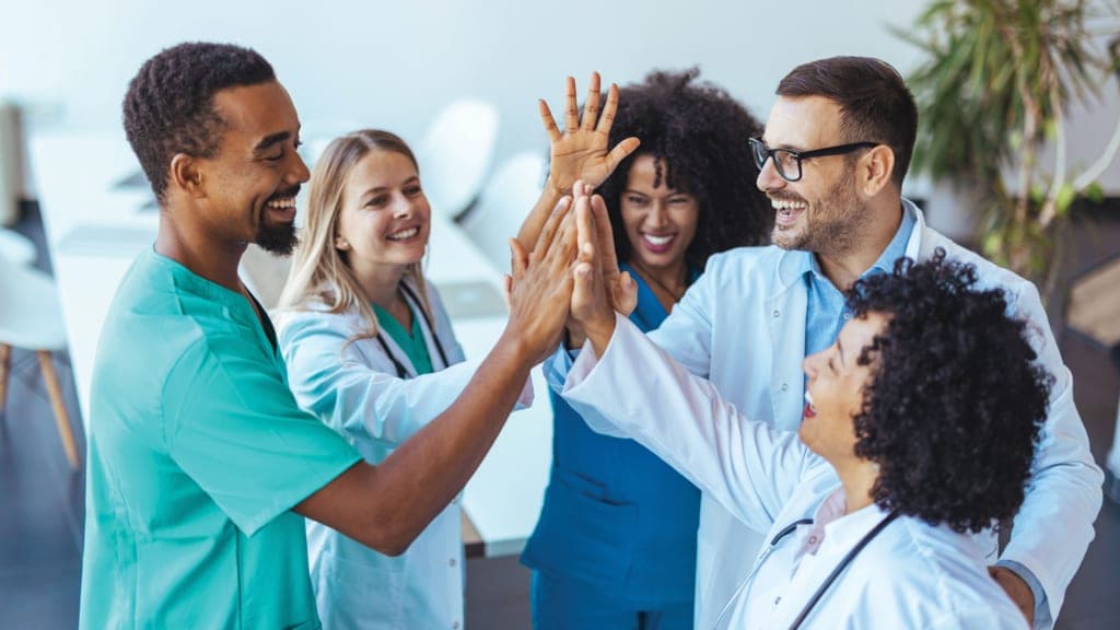 Doctors and nurses celebrating together with a high five