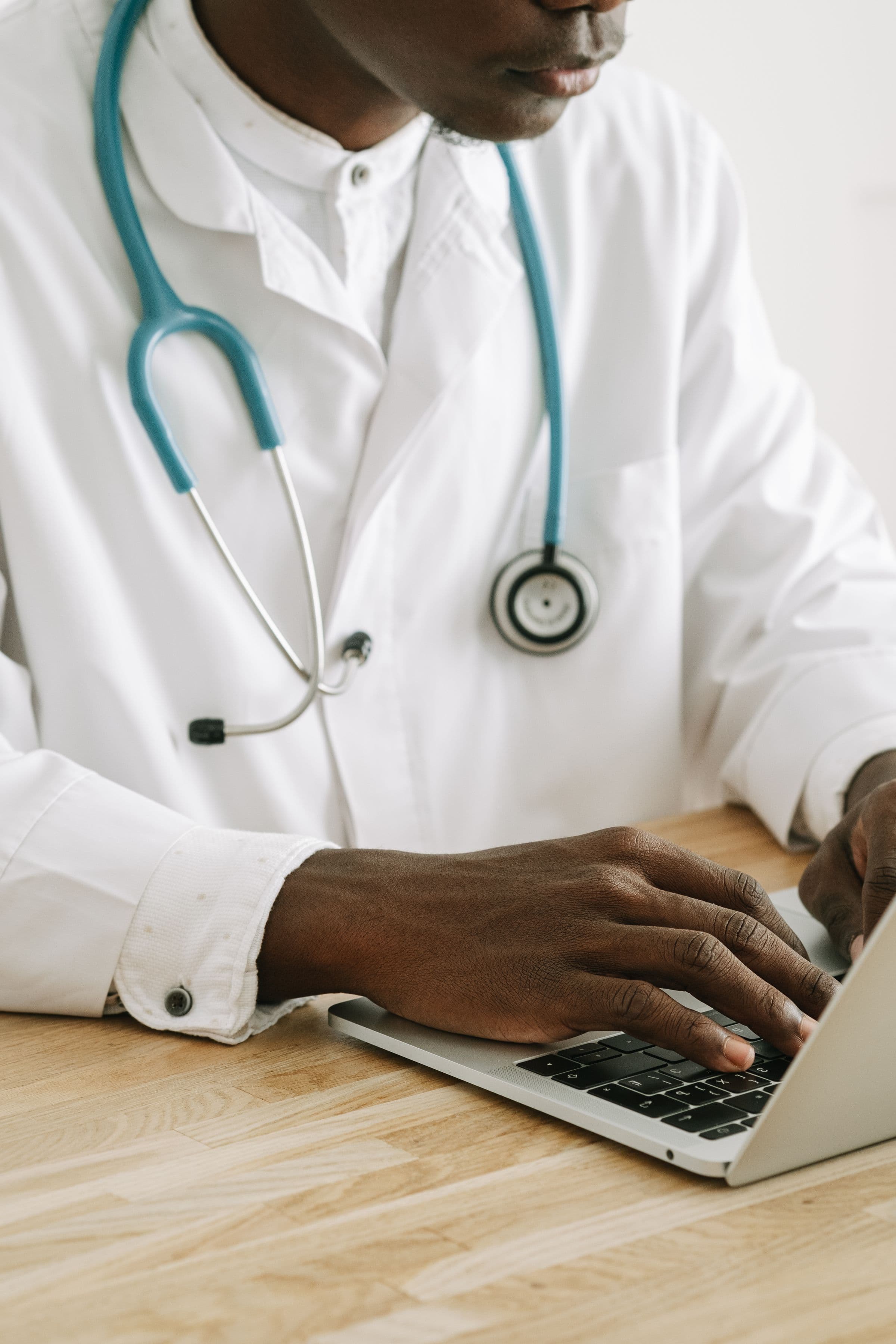 Clinician completing follow-up work on a laptop
